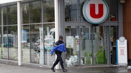 Un gendarme passe devant le Super U de Trèbes (Aude), samedi 24 mars 2018, au lendemain d'une prise d'otage menée par un terroriste jihadiste. (MAXPPP)