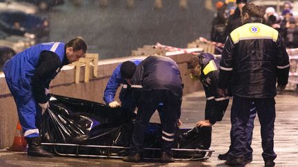 Des secouristes prennent en charge le corps de l'opposant russe&nbsp;Boris Nemtsov, tu&eacute; de quatre balles &agrave; proximit&eacute; du Kremlin&nbsp;&agrave; Moscou (Russie), le 27 f&eacute;vrier 2015. (DMITRY SEREBRYAKOV / AFP)