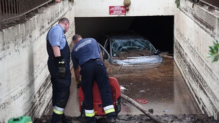 Lundi 5 octobre, des personnes pompent l'eau boueuse dans le parking sous-terrain d'une r&eacute;sidence o&ugrave; quatre personnes ont trouv&eacute; la mort, &agrave; Mandelieu-La-Napoule (Alpes-Maritimes).&nbsp; (ANNE-CHRISTINE POUJOULAT / AFP)