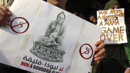 "Non à Bouddha-Flika", indique une pancarte en&nbsp;transformant le président Bouteflika en statue&nbsp;, le 5 mars 2019, lors d'une manifestation à Alger. (ANIS BELGHOUL/AP/SIPA / AP)