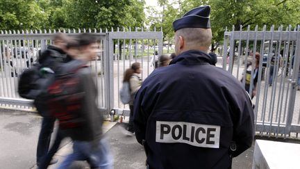 Un policier surveille l'entrée d'un lycée à&nbsp;Strasbourg (Bas-Rhin), en mai 2013. (MAXPPP)