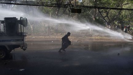 Un pro Jamaat-e-Islami tente d'&eacute;chapper au canon &agrave; eau, devant le consulat fran&ccedil;ais de Karachi (SHAKIL ADIL/AP/SIPA / AP)