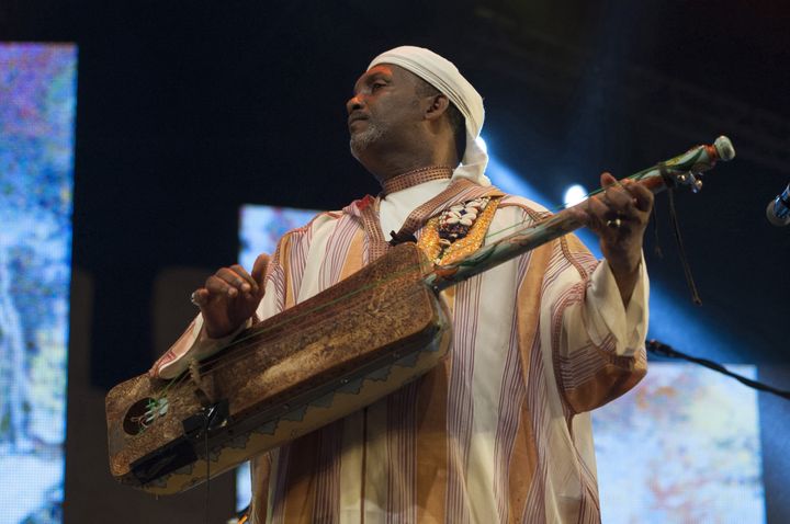 Maâlem Saïd Oughassal, maître de la musique gnaoua, au festival d'Essaouira en juin 2014. Le guembri, sorte de guitare à trois cordes, les qraquech de métal (ou qarqabu, sortes de castagnettes) et les tambours sont les instruments propres à la musique gnaoua du Maroc. (JALAL MORCHIDI / ANADOLU AGENCY)