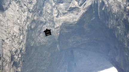 Un homme franchit en wingsuit une arche en Chine, le 24 septembre 2011. (TU TU / IMAGINECHINA / AFP)