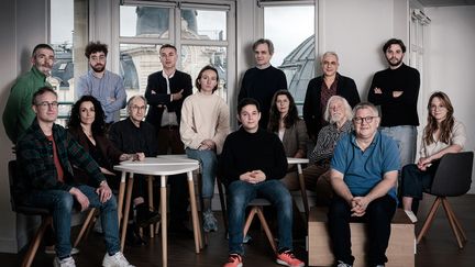 Les membres du journal satirique français Charlie Hebdo (debout de G) : Philippe Lancon, Jean-Loup Adenor, Yann Diener, Riss, Antonio Fischetti, Yovan Simovic, Juin, Coco, Gérard Biard, Lorraine Redaud, Simon Fieschi, Laure Daussy, Willem, Gilles Raveaud et Coline Renault, lors d'une séance photo à Paris, le 26 mars 2024. (JOEL SAGET / AFP)