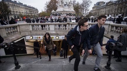 Des usagers sortent du métro place de la République, le 16 novembre 2015 à Paris. (LIONEL BONAVENTURE / AFP)