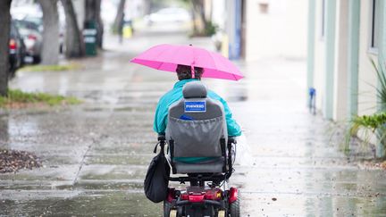 Une femme en fauteuil roulant porte le&nbsp;slogan&nbsp;de campagne d'Obama : "Forward". (EDWARD LINSMIER / GETTY IMAGES)