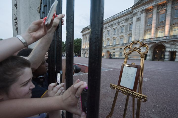 La foule se presse devant les grilles de Buckingham Palace pour lire l'annonce de la naissance du prince George, le 22 juillet 2013, &agrave; Londres.&nbsp; (WILL OLIVER / AFP)