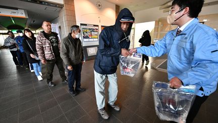 Des habitants de Shika font la queue pour récupérer des réservoirs d'eau potable à la mairie. Au lendemain du séisme, le 2 janvier, plus de 32 000 foyers restent privés d'électricité et de nombreuses agglomérations du département d'Ishikawa n'ont plus accès à l'eau potable. (KAZUHIRO NOGI / AFP)