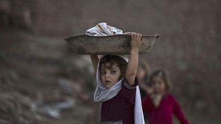 Une jeune r&eacute;fugi&eacute;e afgnane porte du linge dans les faubourgs d'Islamabad (Pakistan), le 22 f&eacute;vrier 2015. (MUHAMMED MUHEISEN / AP / SIPA)