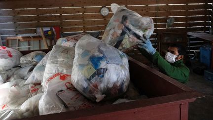 Un ouvrier ramassant des déchets triés dans une déchetterie de la ville de Kamikatsu, dans la préfecture de Tokushima, (photo d'illustration, le 16 juin 2019). (KAZUHIRO NOGI / AFP)