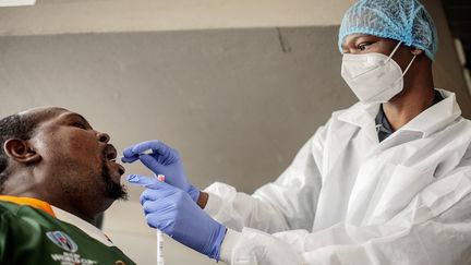 Un patient subit un test salivaire de dépistage du Covid-19 au Lancet Nectare Hospital de Johannesburg, le 18 décembre 2020. (LUCA SOLA / AFP)