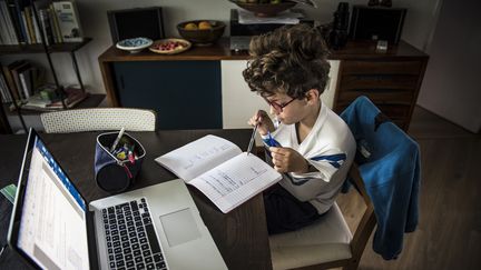 Un enfant fait ses devoirs pendant le confinement, le 23 avril 2020, à Toulouse (Haute-Garonne). (CELINE GAILLE / HANS LUCAS / AFP)