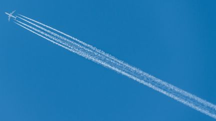 La condensation laissée par les avions forment des trainées blanches. (ROBERT MICHAEL / DPA)