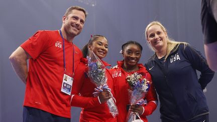 Laurent et Cécile Landi, entourant deux de leurs athlètes, les Américaines Jordan Chiles (à gauche) et Simone Biles (à droite) lors des Trials américains de 2021, à Saint-Louis, le 27 juin 2021. (JAMIE SQUIRE / AFP)