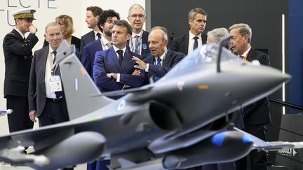 Emmanuel Macron discusses with the general director of Dassault aviation, Eric Trapier during the Paris Air Show, June 19, 2023. (MICHEL EULER / POOL / AFP)