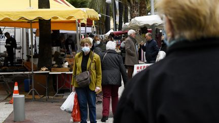 Des personnes continuent à porter le masque sanitaire au marché de Hyeres (Var), le 19 mars 2022. (MAGALI COHEN / HANS LUCAS)