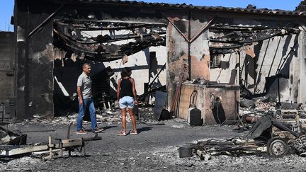 Un homme et une femme constatent les dégâts sur une maison de Bormes-les-Mimosas (Var), mercredi 26 juillet 2017.&nbsp; (ANNE-CHRISTINE POUJOULAT / AFP)