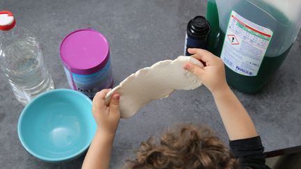 Un enfant joue avec une pate slime fabriquée à la maison.&nbsp; (JEAN-FRAN?OIS FREY / MAXPPP)