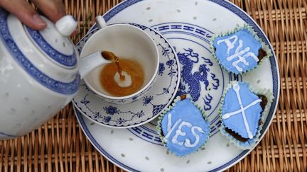 Un membre du groupe des Anglais favorales &agrave; l'ind&eacute;pendances de l'Ecosse offre du th&eacute; et des cupcakes &agrave; la fronti&egrave;re entre l'Angleterre et l'Ecosse, le 7 septembre 2014. (RUSSELL CHEYNE / REUTERS)