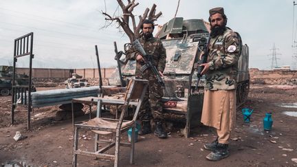 Des soldats talibans devant un char en Afghanistan, le mardi 23 mars 2022. (BENJAMIN GUILLOT-MOUEIX / HANS LUCAS / AFP)