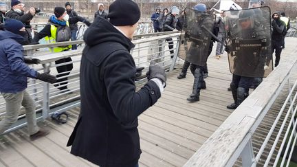 Un homme habillé en noir, de dos, va en découdre avec les forces de l'ordre sur une passerelle enjambant la Seine, à Paris, le 7 janvier 2019.&nbsp; (AFP)