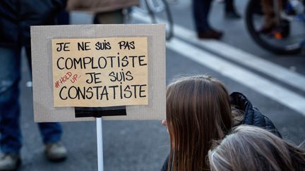 Une manifestante avec une pancarte, lors d'une "marche des libertés" organisée à Paris, en novembre 2020. (MARTIN NODA / HANS LUCAS)