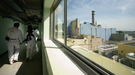 Journalists walk in a corridor of the Hague reprocessing plant (Manche), on August 30, 2024. (LOU BENOIST / AFP)