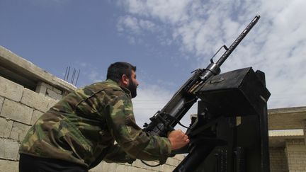 Un rebelle syrien pointe une mitrailleuse vers le ciel, &agrave; Idlib (Syrie), le 18 mai 2013. (ABDALGHNE KAROOF / REUTERS)