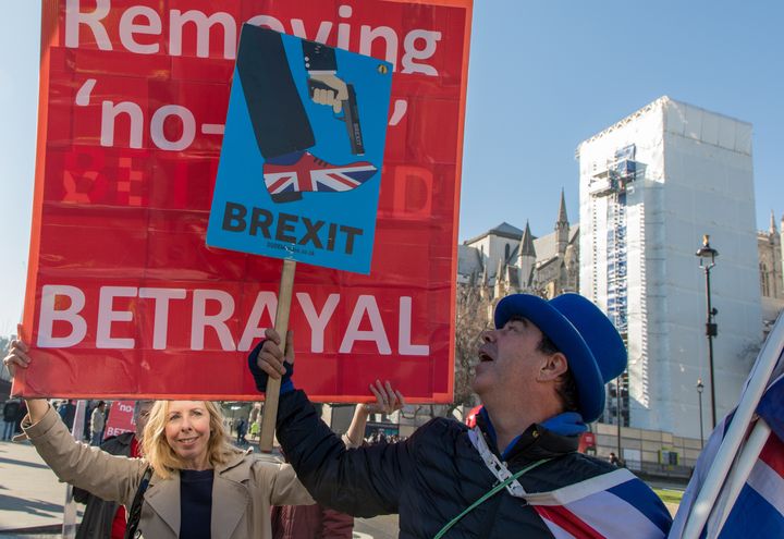 Steve Bray tente de masquer les pancartes des manifestants pro-Brexit, le 26 février 2019, à Londres (Royaume-Uni). (MARIE-VIOLETTE BERNARD / FRANCEINFO)