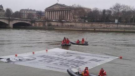 Une banderole est d&eacute;ploy&eacute;e par des militants &eacute;cologistes de Greenpeace sur la Seine, &agrave; Paris, le 9 mars 2015. (GREENPEACE / TWITTER)