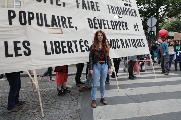 Nina pose devant une banderole reprenant un slogan du Front populaire de 1936, le 15 juin 2024, à Paris (LOUIS DUBAR / FRANCEINFO)