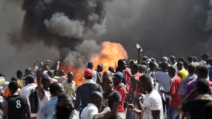 Des Burkinab&eacute;s manifestent devant l'Assembl&eacute;e, le 30 octobre 2014 &agrave; Ouagadougou (Burkina Faso),&nbsp;contre un projet de r&eacute;vision constitutionnelle qui permettrait au pr&eacute;sident de se repr&eacute;senter. (ISSOUF SANOGO / AFP)