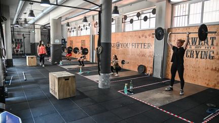 Des clients soulèvent des poids dans une salle de sport à Rome, le 25 mai 2020 (photo d'illustration). (ANDREAS SOLARO / AFP)