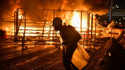 Un manifestant près d'une barricade en feu dans le district de Wajn Chai à Hong Kong, le 31 août 2019.&nbsp; (LILLIAN SUWANRUMPHA / AFP)