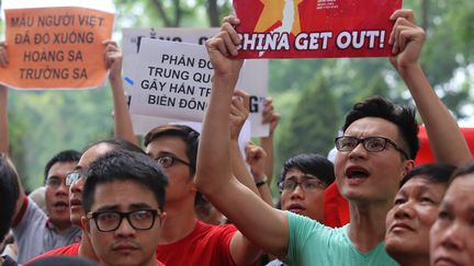 Des manifestants vietnamiens protestent contre l'installation d'une plateforme p&eacute;troli&egrave;re chinoise dans des eaux revendiqu&eacute;es par le Vietnam, le 11 mai 2014, devant l'ambassade de Chine &agrave; Hano&iuml; (Vietnam). (MAI KY / AFP)