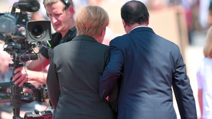 Qui sont ces deux personnes qui marchent dans le zoom des objectifs ? Une chancelière allemande et un président français. 
 (DAMIEN MEYER / AFP)