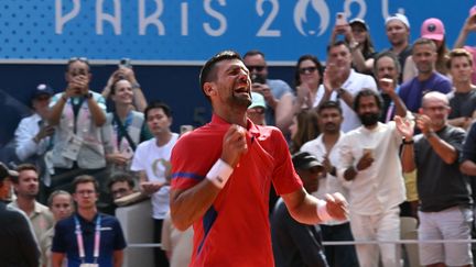 Novak Djokovic célèbre sa victoire en finale du tournoi olympique, le 4 août 2024. (CARL DE SOUZA / AFP)