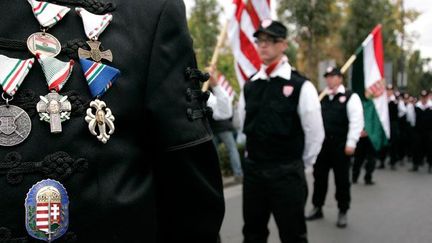 Les uniformes (vestes et gilets noirs) de la Garde hongroise, milice du parti d’extrème droite Jobbik, sont copiés sur ceux des Croix fléchées.  

Vona Gabor, le président de Jobbik, fait scandale en prêtant serment, vêtu de ce costume, lors de la séance inaugurale de l'Assemblée hongroise, le 14 mai 2010. (REUTERS/Karoly Arvai)