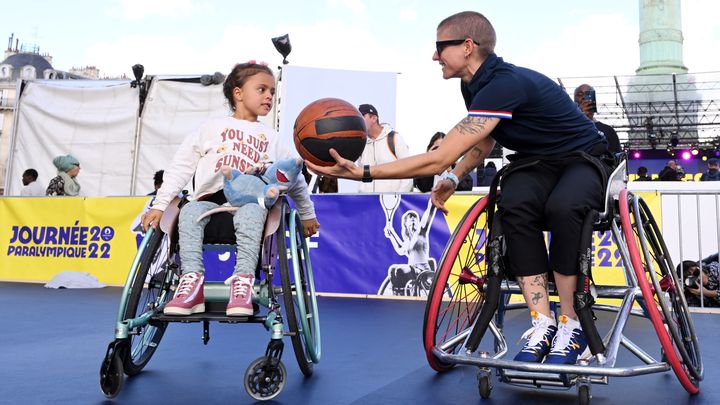 Marie Patouillet s'essaie au basket fauteuil avec une jeune fille lors de la journée paralympique à Paris, le 8 octobre 2022. (MILLEREAU PHILIPPE / KMSP / AFP)