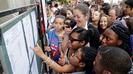 Des lycéens regardent les résultats du bac, le 5 juillet 2017 à Paris. (THOMAS SAMSON / AFP)