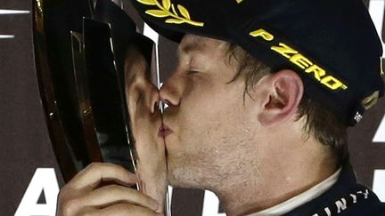 Le pilote allemand Sebastian Vettel embrasse son troph&eacute;e apr&egrave;s avoir remport&eacute; le Grand Prix d'Abou Dhabi (Emirats Arabes Unis), le 3 novembre 2013. (HASSAN AMMAR / AP / SIPA)