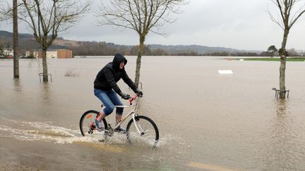 Un homme roule &agrave; v&eacute;lo dans une rue inond&eacute;e par la crue de la Vilaine &agrave; Redon (Ille-et-Vilaine), le 9 f&eacute;vrier 2014. (FRED TANNEAU / AFP)