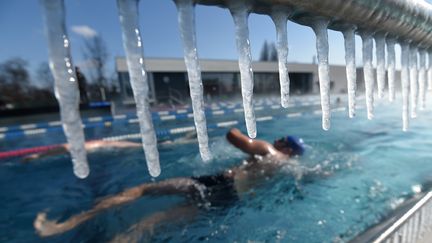 Un nageur profite d'une piscine chauffée à Strasbourg (Bas-Rhin) alors que la température extérieure n'excède pas les -10 degrès, le 26 février 2018.&nbsp; (FREDERICK FLORIN / AFP)