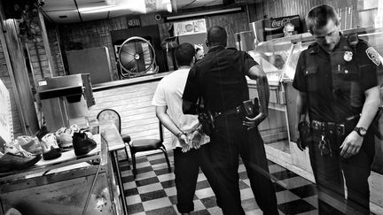 Un g&eacute;rant de fast-food&nbsp;est interrog&eacute;, soup&ccedil;onn&eacute; d&rsquo;avoir menac&eacute; un client&nbsp;avec un fusil de chasse,&nbsp;au nord-est de Rochester (New York, Etats-Unis), en 2012. (PAOLO PELLEGRIN / MAGNUM PHOTOS / POSTCARDS FROM AMERICA)