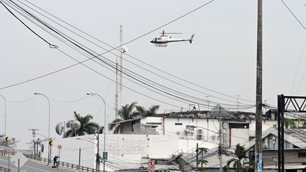 Un hélicoptère de la police équatorienne survole les locaux de la chaîne de télévision TC, après que des hommes armés non identifiés ont fait irruption dans le studio de télévision d'État en direct, le 9 janvier 2024, à Guayaquil. (MARCOS PIN / AFP)