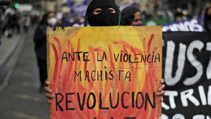 "Face à la violence machiste, la révolution féministe", est-il écrit sur la pancarte de cette manifestante, lors d'une marche organisée à l'occasion de la journée internationale pour l'élimination des violences faites aux femmes, à La Paz (Bolivie), le 25 novembre 2020. (JORGE BERNAL / AFP)