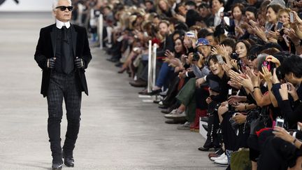 Le couturier allemand Karl Lagerfeld salue le public &agrave; l'issue du d&eacute;fil&eacute; de la collection Chanel printemps-&eacute;t&eacute; 2014 &agrave; Paris, le 1er octobre 2013. (BENOIT TESSIER / REUTERS)