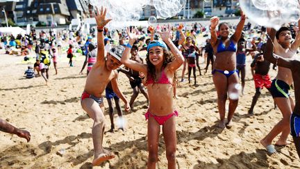 Des enfants qui participent à une opération du Secours populaire jouent sur la plage de Cabourg (Calvados), le 22 août 2018. (CHARLY TRIBALLEAU / AFP)