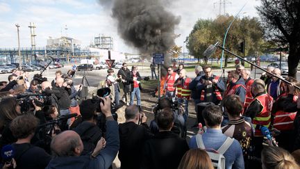 Des syndicalistes devant la raffinerie de Port-Jérôme-Gravenchon (Seine-Maritime), le 12 octobre 2022.&nbsp; (LOU BENOIST / AFP)